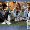 a group of people sitting on grass with a dog